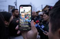 A man records video of Calin Georgescu, an independent candidate for president who won the first round of presidential elections, 8 Dec 2024.
