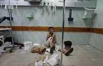 A Palestinian boy who was wounded in an Israeli strike sits on the floor at the emergency room of the Kamal Adwan hospital, 3 August, 2014