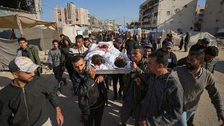 The bodies of three children are carried for burial in Khan Younis, Gaza Strip.