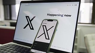 The opening page of X is displayed on a computer and phone, Oct. 16, 2023, in Sydney.