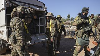 Syrian opposition fighters get off a truck as they enter the village of Anjara, western outskirts of Aleppo, Syria, Thursday Nov. 28, 2024, part of their major offensive on go