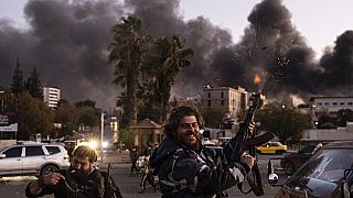 People shoot in the air as they celebrate the fall of the Syrian government in Damascus, Syria, Sunday, Dec. 8, 2024