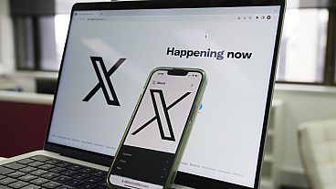 The opening page of X is displayed on a computer and phone, Oct. 16, 2023, in Sydney.