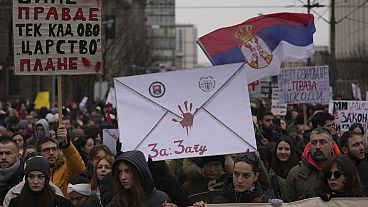 People stopping traffic, stand in silence during ongoing protests that erupted after a concrete canopy fell last month and killed 15 people in front of a government building