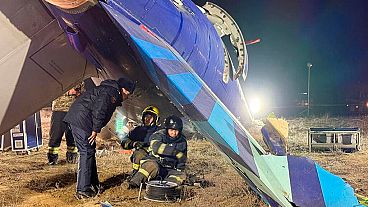 In this photo released by Kazakhstan's Emergency Ministry Press Service, rescuers work at the wreckage of Azerbaijan Airlines Embraer 190 lies on the ground near the airport.