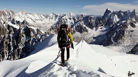 An alpinist heads down a ridge on the Aiguille du Midi towards the Vallee Blanche on the Mont Blanc massif, in the Alps, near Chamonix, France.