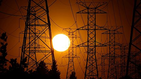 The sun sets behind high tension power lines in Los Angeles. September 2024. 